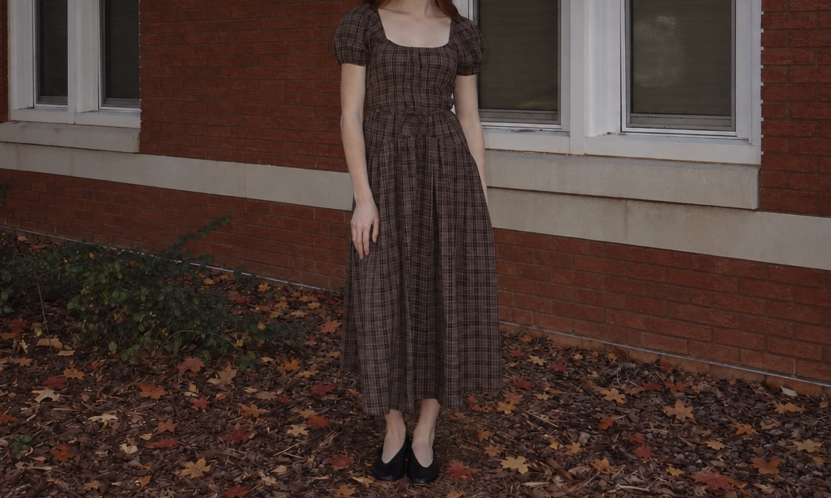Darla fall collection plaid dress photographed against brick and autumn leaves